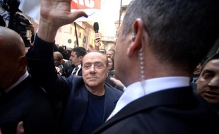 Silvio Berlusconi, entouré de gardes du corps, salue ses supporteurs, le 11 mars 2015 à Rome
