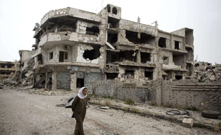 Homs, Syrie, le 5 juin 2014. Une femme marche dans les rues dévastées de la ville de Homs.