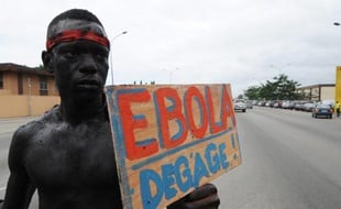 Un homme tient une pancarte "Ebola dégage" à l'occasion d'une marche de sensibilisation de la population au virus Ebola, le 19 août 2014 à Abidjan en Côte d'Ivoire