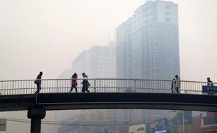 Des habitants de Shenyang sur un pont piétonnier, lors d'un jour de pollution en 2015 (photo d'illustration)