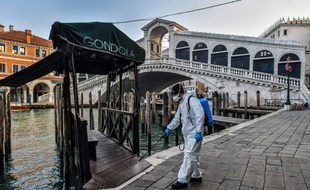 Un employé désinfecte les rues à proximité du pont Rialto à Venise, le 11 mars 2020.