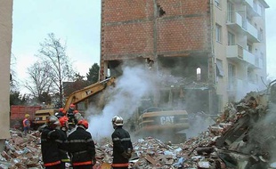Les pompiers sur les débris d'un immeuble à Mulhouse, après son explosion accidentelle, le 27 décembre 2004.