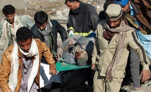 Des Yéménites portent le corps d'une victime des bombardements de l'aviation saoudienne, le 26 mars 2015 à Sanaa