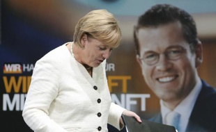La chancelière allemande, Angela Merkel, devant une affiche électorale sur laquelle figure son actuel ministre de l'Economie
Karl-Theodor zu Guttenberg, le 17 août 2009.