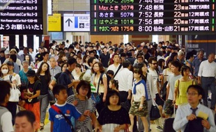Des voyageurs dans une gare de Tokyo, le 13 août 2014