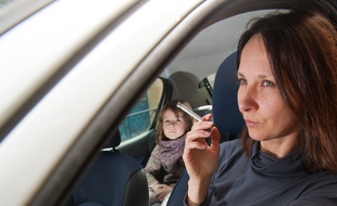 Bordeaux, 27 mars 2013. - Jeune femme fumant au volant en presence d'un enfant. - Photo : Sebastien Ortola
