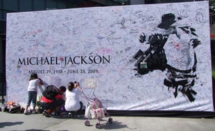 Les fans laissent leur message sur le mur à l'effigie de Michael Jackson, devant le Staples Center de Los Angeles où se déroule, mardi 7 juillet, la cérémonie d'hommage.