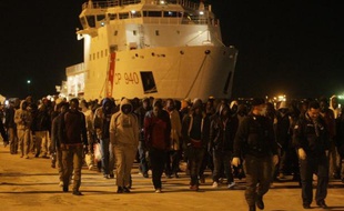 Des migrants débarquent d'un bateau en Sicile après une opération de sauvetage des gardes-côtes, le 4 mars 2015