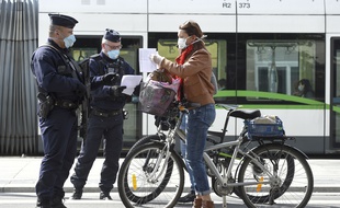 Des policiers contrôlent l'attestation de déplacement d'une cycliste, à Nantes.