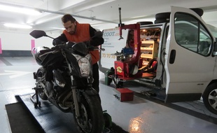 Martial, l'un des trois mécaniciens d'Izyscoot, sillone les parkings de La Défense avec son atelier de réparation de scooters et motos mobile.