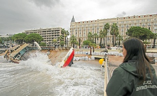 Devant le Carlton, à Cannes, image insolite d'un cargo échoué sur la plage.