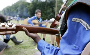 Des scouts et guides de France jouent de la guitare au Chateau de Jambville, près de Paris, le 30 juillet 2015