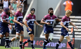 Bordeaux's players walk onto the pitch after scoring a try during the French Top 14 rugby union match between Union Bordeaux-Begles (UBB) and Montpellier on September 14, 2014 at the Chaban-Delmas stadium in Bordeaux. AFP PHOTO / NICOLAS TUCAT