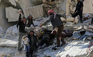 Des civils et des secouristes cherchent des victimes dans les décombres d'un bâtiment à la suite de frappes aériennes gouvernementales à Alep le 7 décembre 2015