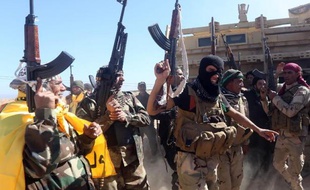 Des forces irakiennes se réjouissent à leur entrée dans la ville de Tikrit, qu'elles cherchent à reprendre aux jihadistes depuis plus d'une semaine, en Irak, le 11 mars 2015