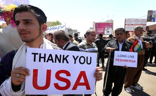 Des chrétiens et des Kurdes d'Irak brandissent des pancartes remerciant les Etats-Unis, dans la province d'Arbil dans le nord du pays.