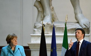 Le chef du gouvernement italien Matteo Renzi prononce un discours à côté de la chancelière allemande Angela Merkel le 23 janvier 2015 dans la Galleria dell'Accademia, devant l'imposante sculpture du XVIème siècle "David", de Michel-Ange