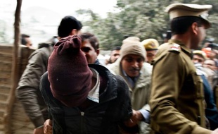 Des policiers indiens (à gauche) escortent un suspect du viol en réunion d'une touriste danoise devant le tribunal de Tis Hazari à New Delhi le 16 janvier 2014