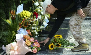Un touriste fleurit la tombe de Pablo Escobar à Medellin le 2 décembre 2015