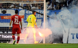 Anthony Lopes, gardien lyonnais ramasse un fumigène lancé sur le terrain à Marseille le 20 septembre 2015