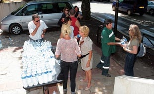 Des volontaires distribuent des bouteilles d'eau dans les rues de Draguignan, le 17 juiin 2010, deux jours après les inondations meurtrières.