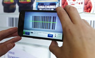 Un voyageur fait ses courses de manière virtuelle à l'aéroport de Gatwick à Londres grâce à son smartphone.