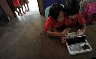 Dans une classe du nord thaïlandais, des élèves font glisser leurs doigts sur des écrans tactiles. Comme eux, 850.000 écoliers utilisent des tablettes censées améliorer un système éducatif sujet à polémique, mais certains doutent de la pertinence d'un programme qui va être généralisé.