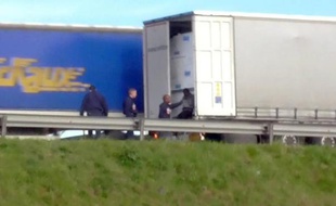 Image tirée d'une vidéo fournie par l'association Calais Migrant Sodidarity (CMS) montrant des policiers et un migrant sur le bord d'une route près de Calais dans le nord de la France, le 12 mai 2015