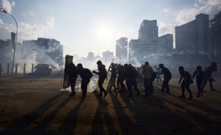 Des manifestants affrontent la police anti-émeute à Caracas, au Venezuela, le 16 mars 2014.