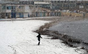 Un promeneur sur une plage de Marseille pendant un épisode de neige en 2018