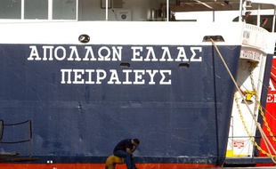Un bateau et un employé dans le port du Pirée, près d'Athènes, le 29 juin 2010. Ce port pourrait être vendu pour désendetter le pays.