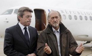L'ex-otage Pierre Camatte (à d) répond aux journalistes à son retour de captivité, le 25 février 2010 sur l'aéroport de Villacoublay aux côtés d'Alain Joyandet, alors secrétaire d'Etat à la Coopération