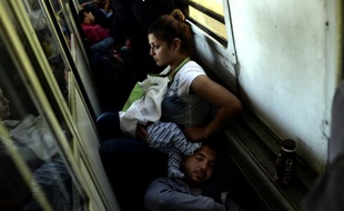 Des réfugiés irakiens Ahmad, Alia et leur bébé Adam voyagent, le 30 août 2015 dans un train de la Macédoine à la Serbie, dans le cadre de leur périple pour rejoindre l'Allemagne