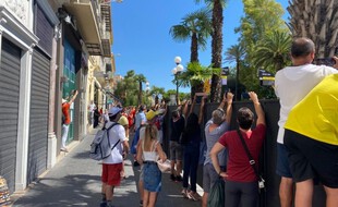 Un public masqué assiste au départ fictif de la deuxième étape du Tour de France, avenue de Verdun à Nice.