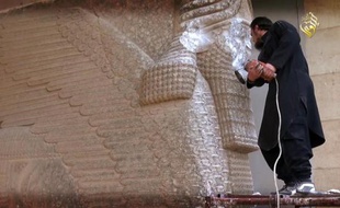 Image tirée d'une vidéo fournie par le groupe EI le 26 février 2015 montrant un militant détruisant un taureau ailé assyrien sur un site archéologique de Mossoul
