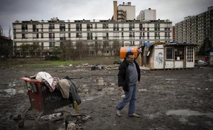 Un homme porte une bouteille de gaz dans un camp de roms à Ivry-sur-Seine, le 18 décembre 2014