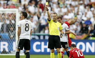 Referee Bjorn Kuipers shows a yellow card to Germany's Mesut Ozil, left, during the Euro 2016 Group C soccer match between Germany and Poland at the Stade de France in Saint-Denis, north of Paris, France, Thursday, June 16, 2016. (AP Photo/Christophe Ena)/HAS193/569429350904/1606162153