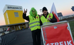 Employees of internet retail giant Amazon stage a strike in front of the company's logistics center in Bad Hersfeld, central Germany, on December 16, 2013, during the busy Christmas holiday period. Amazon employees again went on strike over pay. Germany's service-sector union Verdi has been trying for months to get Amazon to bring the pay of its 9,000 workers in Germany in line with wages in the distribution sector. AFP PHOTO / DPA / UWE ZUCCHI / GERMANY OUT