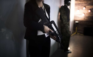 Une femme tient un Famas, le célèbre fusil d'assaut français