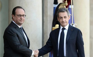Le président français François Hollande (g) salue son prédécesseur à l'Elysée Nicolas Sarkozy à Paris le 15 novembre 2015