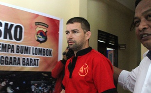 Flix Dorfin, escorté par la police indonésienne après son arrestation. à Lombok.