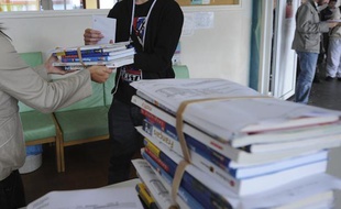 Un professeur remet ses manuels scolaires à un élève dans un collège à Nantes.