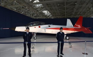 Des militaires japonais se tiennent devant le X-2, un avion de chasse présenté comme étant capable d'esquiver les radars, le 28 janvier 2016