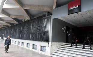 Un homme passe devant une agence de la SGBCI, la filiale ivoirienne de la Socitété générale, à Abidjan, le February 18, 2011. Deux hommes de garde sont postés devant l'agence.
