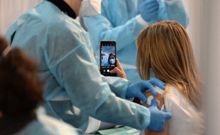 Une femme en train de se filmer pendant la vaccination.