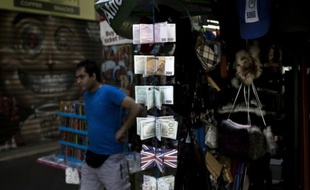 Un homme passe devant un présentoir avec des porte-monnaies remplis des imitations de billets d'euros, le 25 juillet 2015 à Athènes