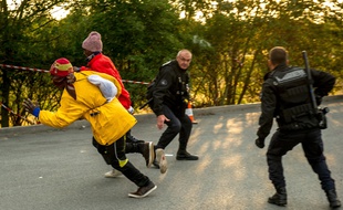 Des gendarmes français tentent debloquer un migrant après qu'il a pénétré sur le site d'Eurotunnel AFP PHOTO / PHILIPPE HUGUEN