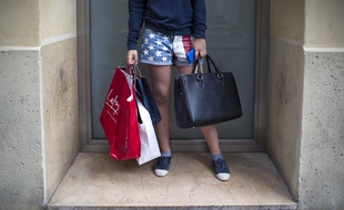 Illustration d'une adolescente avec des sacs, à la sortie d'un magasin du boulevard Haussmann à Paris.