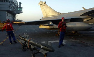 Des techniciens s'affairent autour d'un avion Rafale revenant d'une mission en Irak, sur le pont du porte-avions Charles de Gaulle, le 26 février 2015