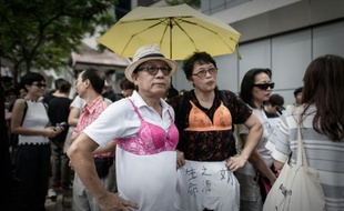 Des manifestants en soutien gorge protestent le 2 août 2015 à Hong Kong contre la condamnation d'une femme condamnée à trois mois et demie de prison pour avoir agressé un policier avec sa poitrine pendant une marche contre la hausse des prix